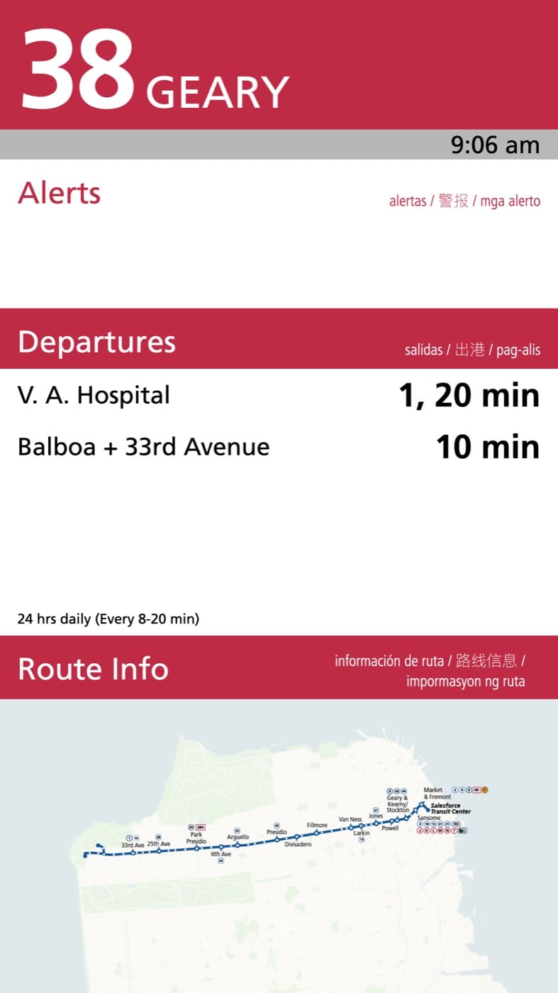 A tall platform pylon display showing a route badge, a service alert, and live departure times